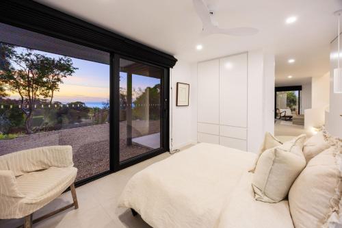 a bedroom with a large window and a bed and a chair at Grandview Lookout - McCrae in McCrae