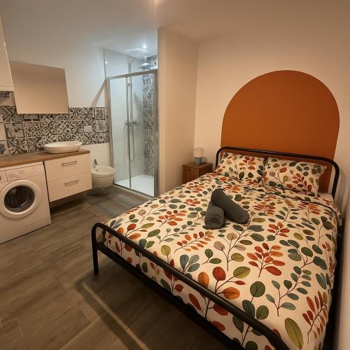 a bedroom with a bed with a flowered comforter at Studio Bleu tout équipé au calme proche des commerces in Briord
