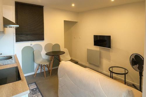 ein Wohnzimmer mit einer Couch und einem Tisch und Stühlen in der Unterkunft Studio Rénové tout équipé au calme proche des commerces in Briord