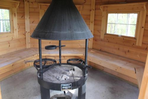 a fireplace in a log cabin with a lamp at Maatilamatkailu Jänisvaara in Kolinkylä