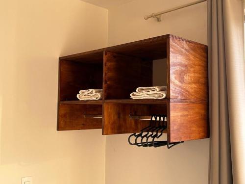 un mobiletto di legno appeso al muro con degli asciugamani di Apartamento noCentro de Guarapuava a Guarapuava