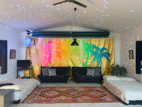 a living room with a couch and a colorful curtain at The Disco Studio in Gleniffer