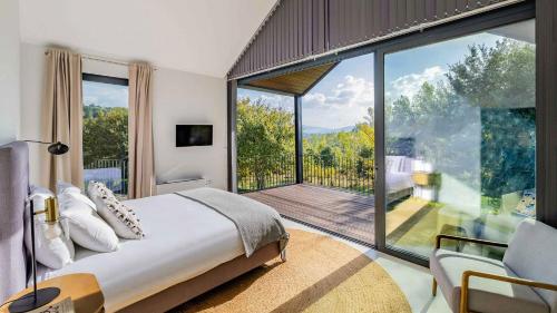 a bedroom with a bed and a large glass window at Quinta da Lameirinha Douro, Boutique Home in Baião