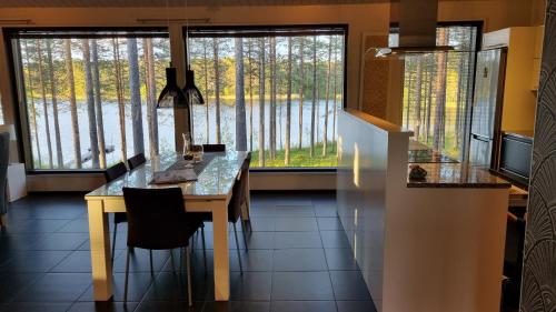 una cucina con tavolo e vista sul lago di Harjunranta a Kuusamo