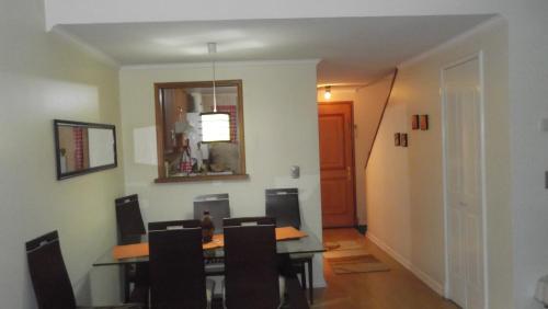 a dining room with a table and some chairs at Departamento Duplex Centro Pucon in Pucón