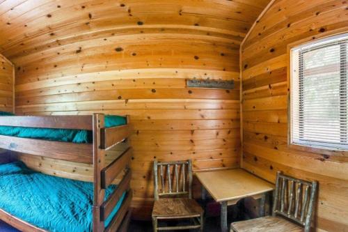 een blokhut met een stapelbed en twee stoelen bij Yosemite Lakes Bunkhouse Cabin 27 in Harden Flat