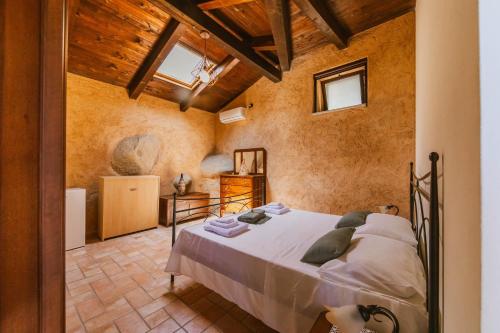 une chambre avec un lit dans une pièce avec des plafonds en bois dans l'établissement Calàmi - Villa Romeo - Private Apartments with Pool, Seaview & Olive Grove, à Santa Caterina Dello Ionio Marina