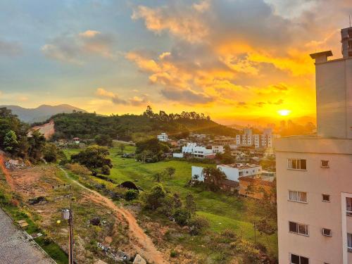 een uitzicht op een stad met de zonsondergang op de achtergrond bij CURTA! |165| Lindo Studio | Próx Centro de Eventos in Balneário Camboriú