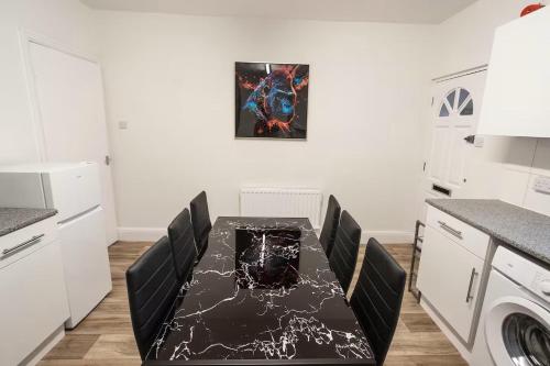 a kitchen with a black table and black chairs at 3-Bedroom Flat-FreeParking & Wifi, Sleeps7 in Bristol