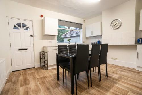 a kitchen with a black table and black chairs at 3-Bedroom Flat-FreeParking & Wifi, Sleeps7 in Bristol