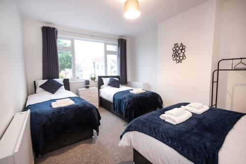 a bedroom with two beds and a window at 3-Bedroom Flat-FreeParking & Wifi, Sleeps7 in Bristol