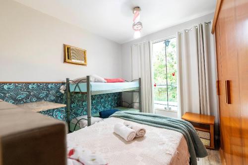 Un dormitorio con dos literas y una ventana. en Apartamento Moderno com vista para á principal, en Volta Redonda