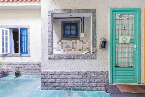 un edificio con una puerta verde y una ventana en Apartamento Moderno com vista para á principal, en Volta Redonda