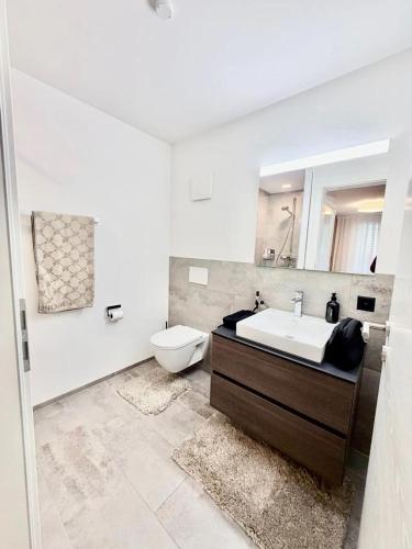 een witte badkamer met een wastafel en een toilet bij Am apartment in Pristina