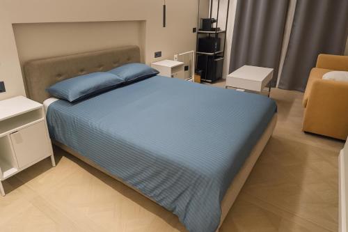 een slaapkamer met een blauw bed en een stoel bij Centro & Mare 2 Essential - Rooms - Garage in Termoli