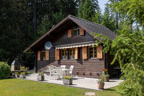 una cabina di legno con tavolo e sedie di fronte di Le Petit Mayen a Châtel-Saint-Denis