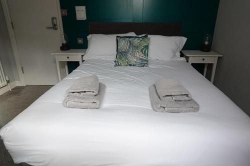 a bed with towels on top of it at Victorian Suites - Spacious 2 Bed Apartment in Southport