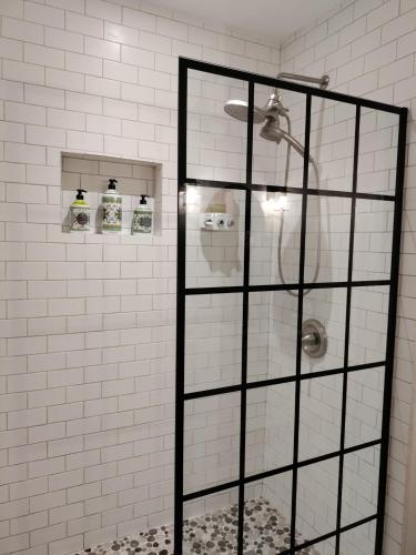 a shower in a white tiled bathroom at House Close to Downtown, Airport, Raymond James Stadium, and Many More Places in Tampa