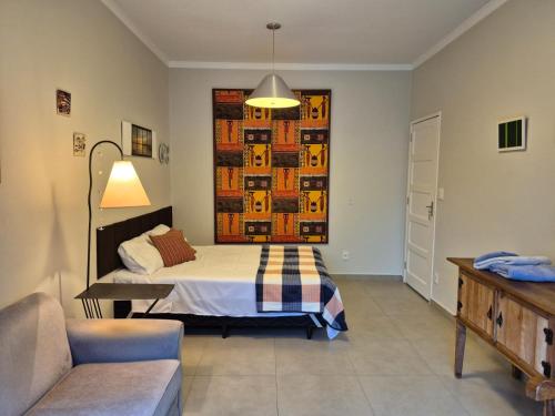 a bedroom with a bed and a couch at Chalé de Sampa in São Paulo