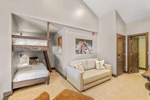 a bedroom with a bunk bed and a couch at Bear Claw 405 - Luxury Condo, Ski-in Ski-out Access, Slope Views & Winter Shuttle! in Steamboat Springs