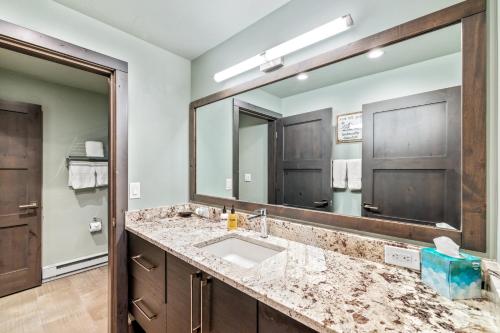 a bathroom with a sink and a large mirror at Bear Claw 405 - Luxury Condo, Ski-in Ski-out Access, Slope Views & Winter Shuttle! in Steamboat Springs