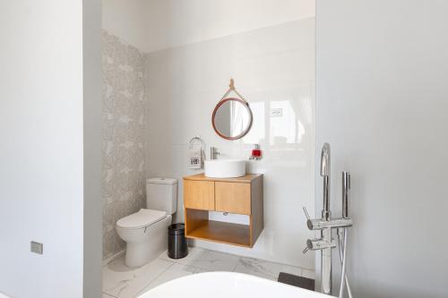 a bathroom with a toilet and a sink and a mirror at Hotel H4 Olanchito in Olanchito