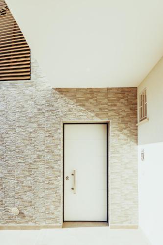 a white door in front of a brick wall at Ellenove holiday house in Tortoreto Lido