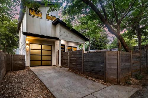 a house with a wooden fence and a garage at East Side Haven - Blocks from Local Food Legends in Austin