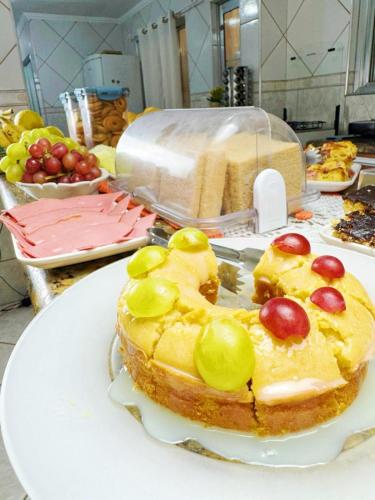 um bolo num prato com uvas por cima em Hostel Anprado #9 em Guarulhos