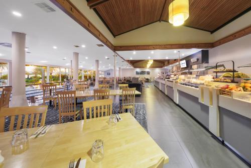 a restaurant with tables and chairs and a buffet at Copthorne Hotel & Resort Bay Of Islands in Paihia