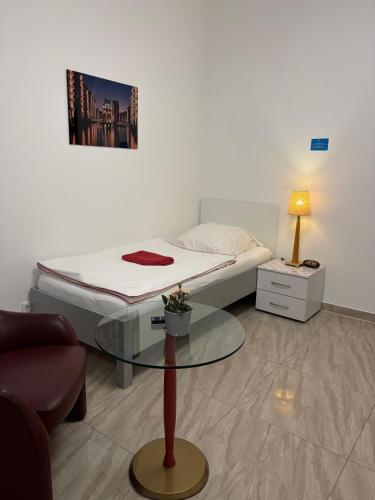 a room with a bed and a glass table at Sleep2Fly Hamburg-Airport in Hamburg