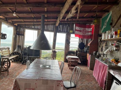 ein Esszimmer mit Tisch und Stühlen und Fenstern in der Unterkunft CasaRiva in Biguaçu