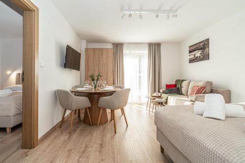 a living room with a bed and a table in a room at Ski Mountain Apartamenty - Plac zabaw - Dmuchaniec - Plac zabaw - Wypożyczalnia rowerów elektrycznych E-Bike Białka in Białka Tatrzańska