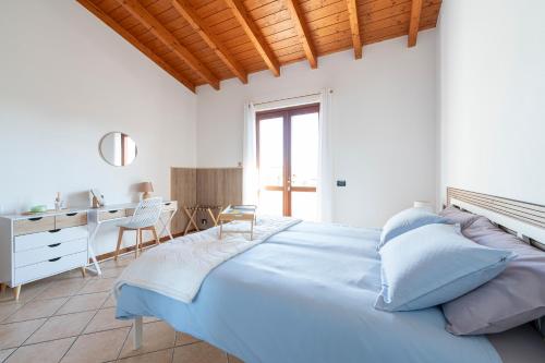 a bedroom with a large blue bed and a desk at Green Hill apartment in Salò