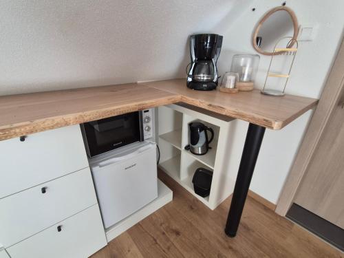 Una mesa con encimera de madera con microondas. en Maison chaleureuse, en Griesheim-près-Molsheim