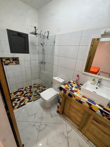 une salle de bains avec toilettes et lavabo dans l'établissement Villa Warang, à Warang
