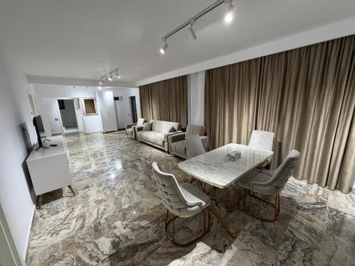 un soggiorno con tavolo, sedie e divano di Therme One Level Villas a Baloteşti