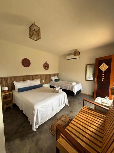 a hotel room with two beds and a couch at Vila Orun Pousada in Barreirinhas