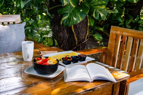 a table with an open book and a plate of food at El Xalli Hotel in El Zonte