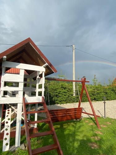 Una silla de madera y un columpio en un patio. en W Borze, en Czarna Góra