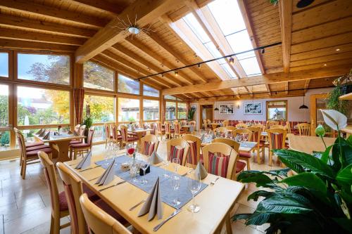 a dining room with tables and chairs and windows at Gasthof Rose in Langenaltheim