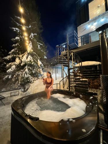 Una mujer en un jacuzzi en la nieve en Forest Hub, en Slavske