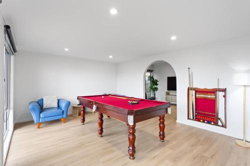 a room with a pool table and a blue chair at Newly Renovated Home in Heart of Cowes in Cowes