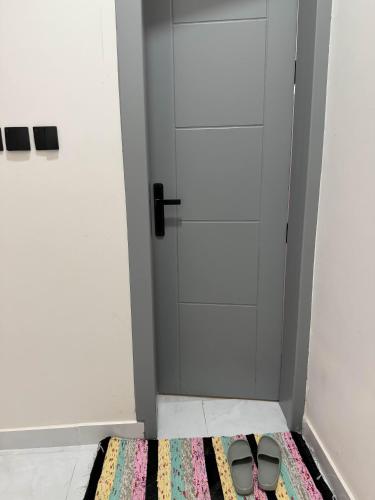 a pair of shoes on a rug in front of a door at استديو بجلسة بمطبخ مستقل دخول ذاتي 13 in Buraydah