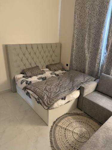 a bedroom with a bed and a chair and a rug at استديو بجلسة بمطبخ مستقل دخول ذاتي 13 in Buraydah