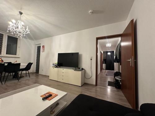 een woonkamer met een televisie en een eetkamer bij Jonas Haus Gästezimmer in Berlijn