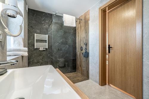 a bathroom with a shower and a white tub at Ski Mountain Apartamenty - Plac zabaw - Dmuchaniec - Plac zabaw - Wypożyczalnia rowerów elektrycznych E-Bike Białka in Białka Tatrzańska