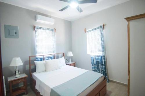 una camera da letto con un letto e due finestre di Casa Palma a Placencia