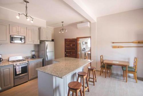 una cucina con un bancone, un tavolo e delle sedie di Casa Palma a Placencia