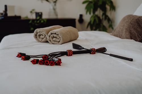 eine schwarz-rote Schleife auf einem Bett in der Unterkunft Luxus-Apartment Champagner&Strafbock in Herford